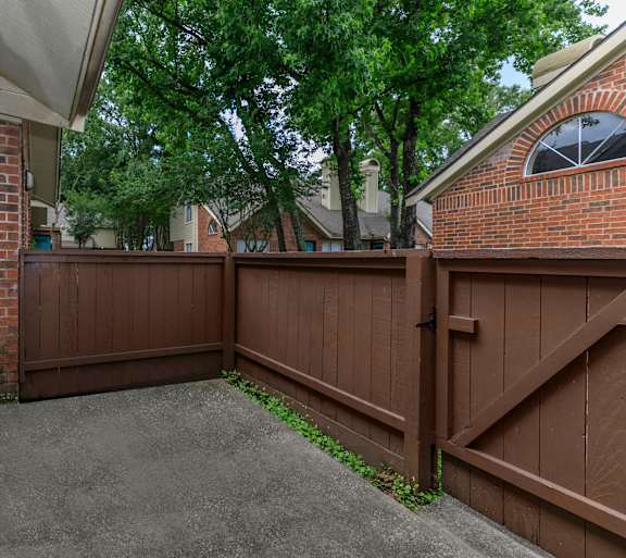 A brown wooden fence in front of a house.