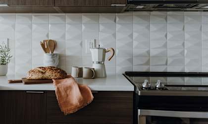 a kitchen with white tiles and dark wood cabinets