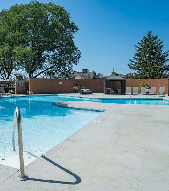 A large outdoor swimming pool surrounded by trees.