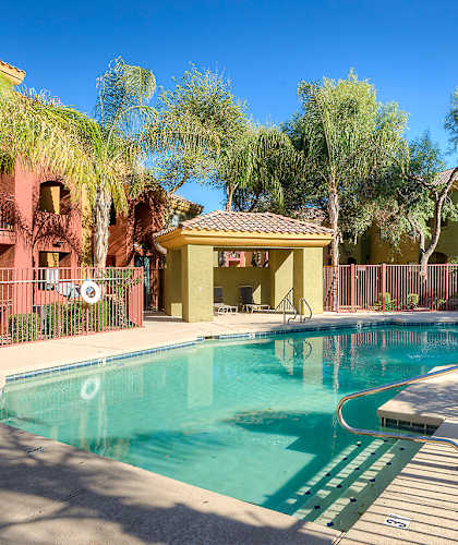 A pool surrounded by buildings and trees.