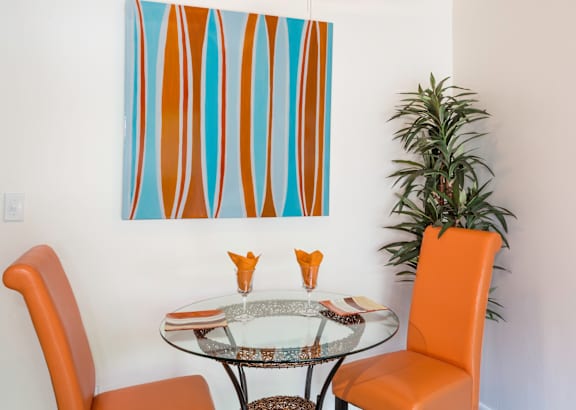 A dining room with a glass table and chairs.