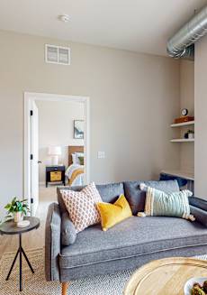 A living room with a grey couch and a small table.