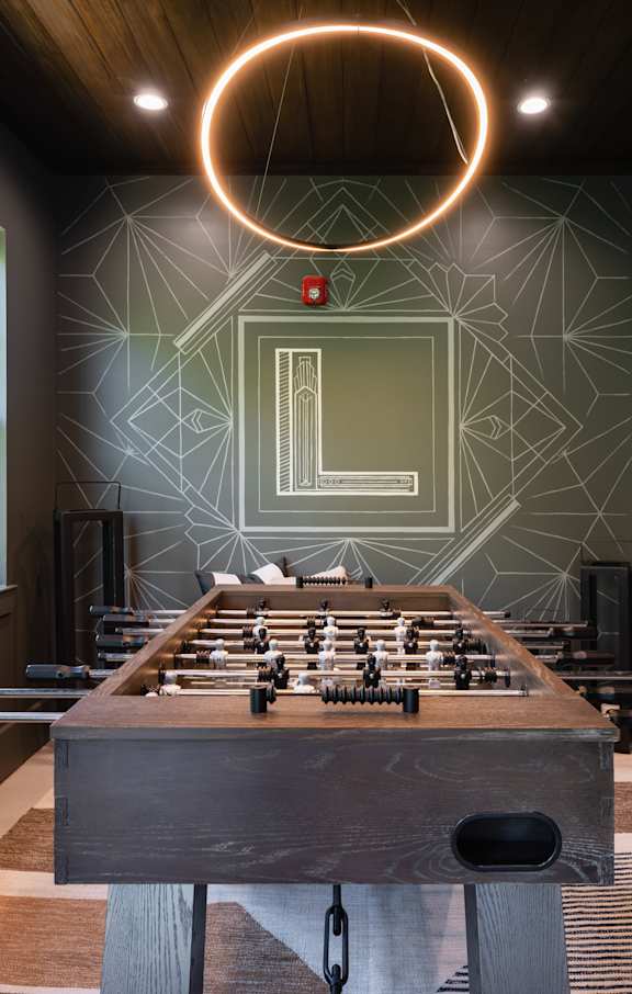 A foosball table in a room with a geometric pattern on the wall.