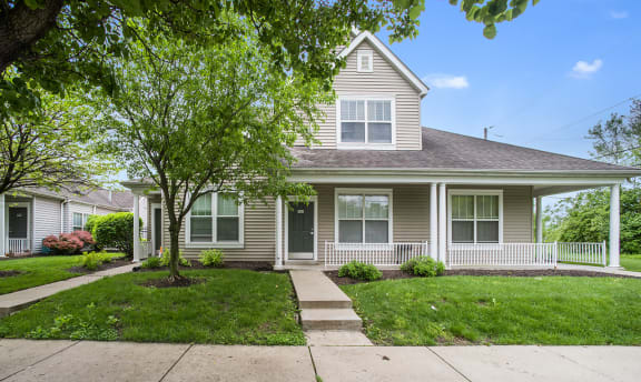 a house with a sidewalk and trees in front of it