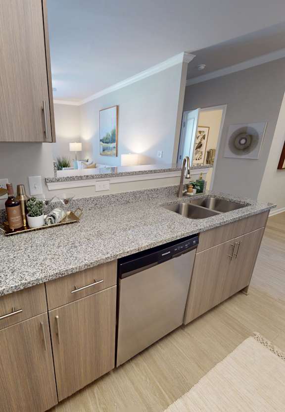 A kitchen with a granite countertop and wooden cabinets.