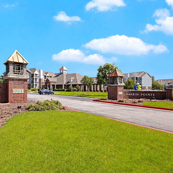 The entrance to Harbin Pointe Apartment Homes with a view of the apartments and the outdoor brick gates. 