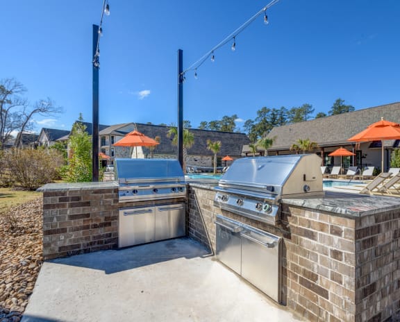 two stainless steel appliances on a patio next to a swimming pool