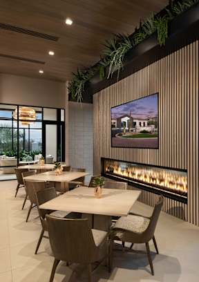 A modern dining room with a long table and chairs.