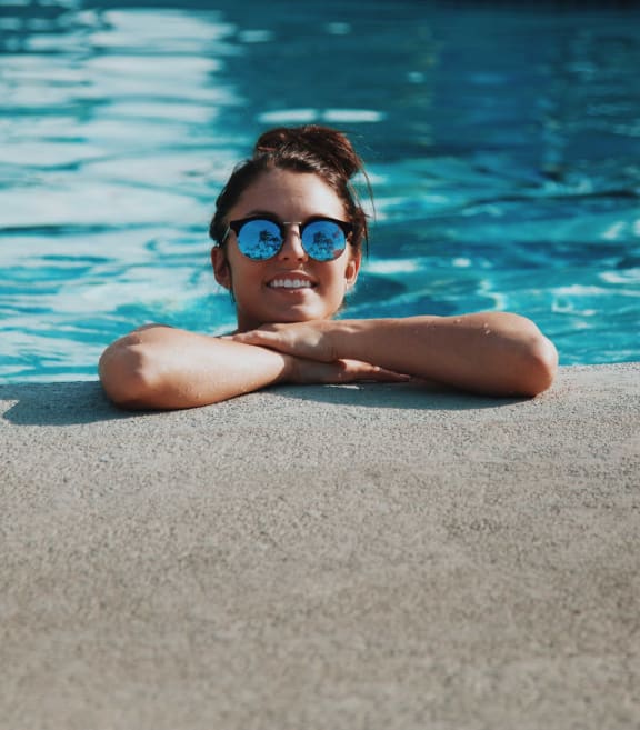 a large pool with chairs and a fence around it
