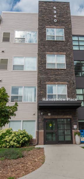 an apartment building with a sidewalk in front of it