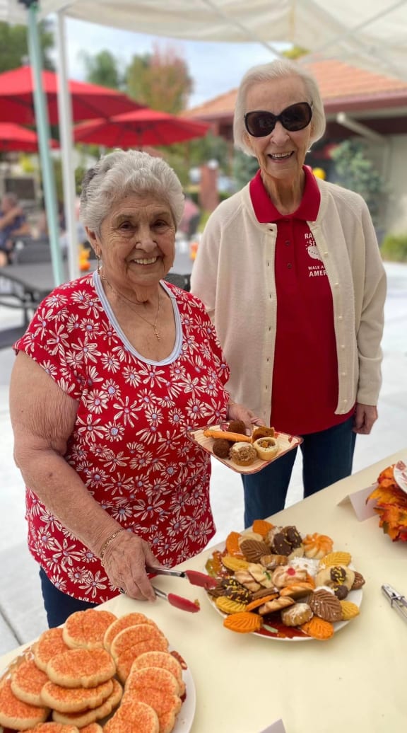 two elderly women sitting at a table with a bottle of wine at Roseville Commons Senior Living, Roseville, CA 95678