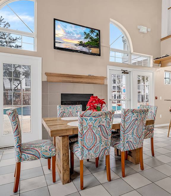 A room with a large table surrounded by chairs.