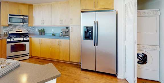 A modern kitchen with wooden cabinets and stainless steel appliances. at Esprit Apartments, Marina del Rey, CA