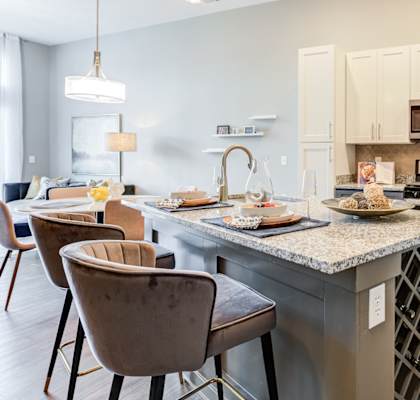 A kitchen with a table and chairs in front of it.