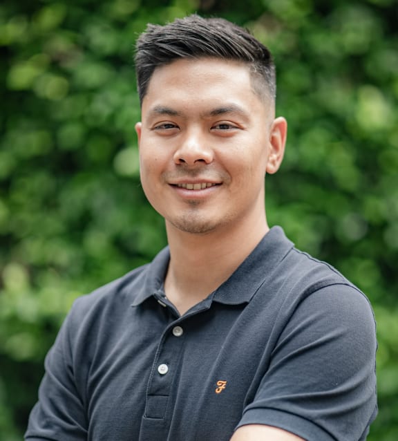 a portrait of a young man with his arms crossed