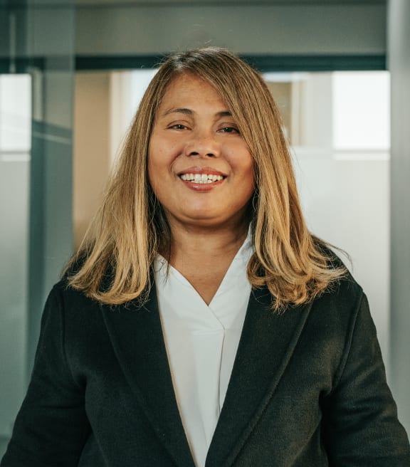 a woman wearing a suit and smiling in an office