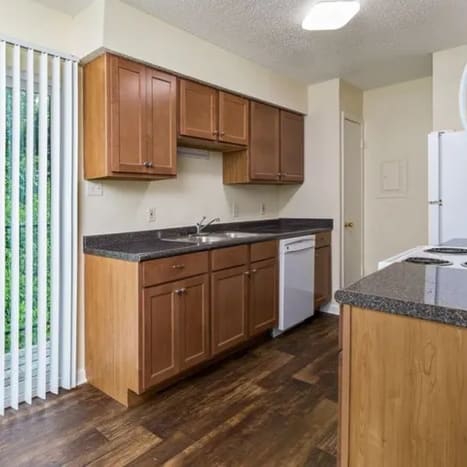 A kitchen with wooden cabinets and a white refrigerator.