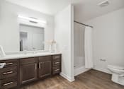 Thumbnail 11 of 18 - a bathroom with a large mirror and a toilet and a sink