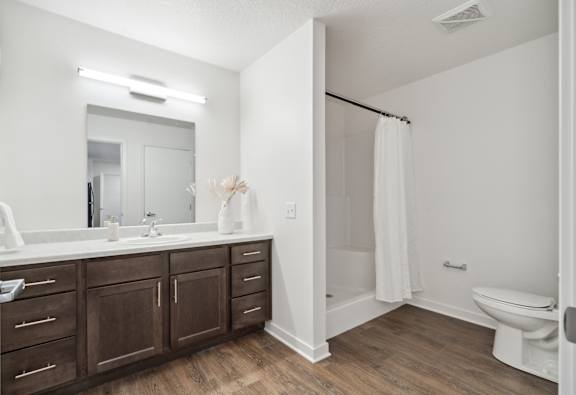 a bathroom with a large mirror and a toilet and a sink