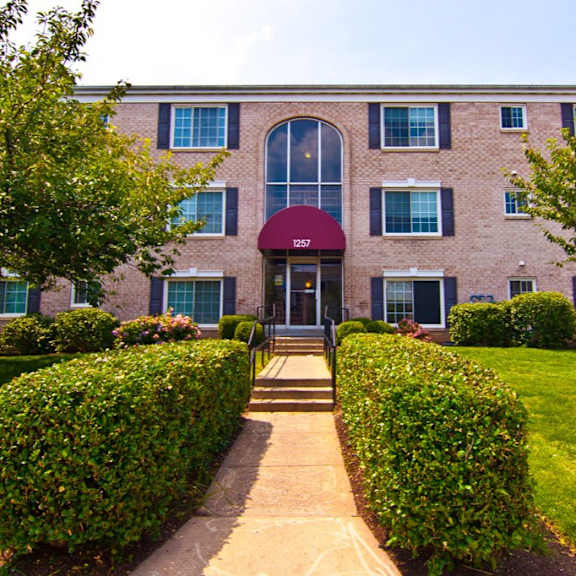 A bedroom with a bed, bench, and window at Dulles Glen Apartments, Virginia, 20170