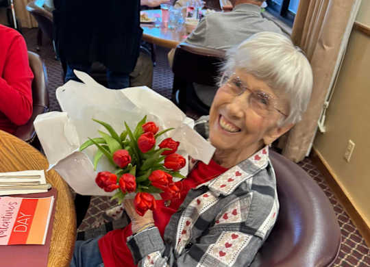Elderly woman with roses at River Commons Senior Living, Redding, CA