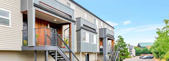 A modern apartment building with a red-painted walkway in front.