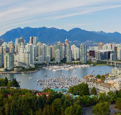 A cityscape with a body of water and mountains in the background.