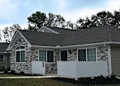 Thumbnail 7 of 36 - a house with a white fence and a street in front of it