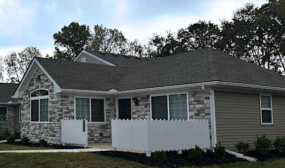a house with a white fence and a street in front of it