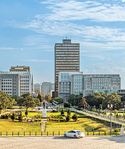 A cityscape with a clear blue sky and a few clouds.