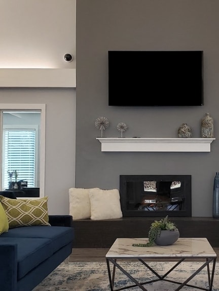 a living room with two blue couches and a coffee table in front of a fireplace