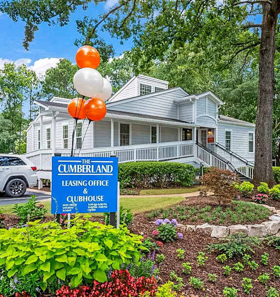 A white house with a sign that says "The Cumberland Leasing Office & Clubhouse".