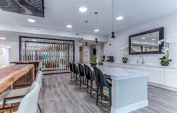 A modern kitchen with a long white island and bar stools.at Tiffany Flats, Columbus, OH, 43231