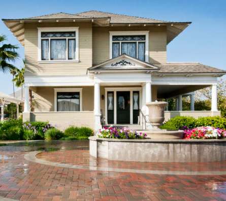 A large house with a fountain in front.
