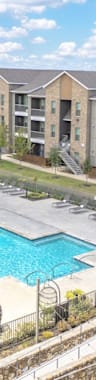A swimming pool in a residential area surrounded by apartment buildings.