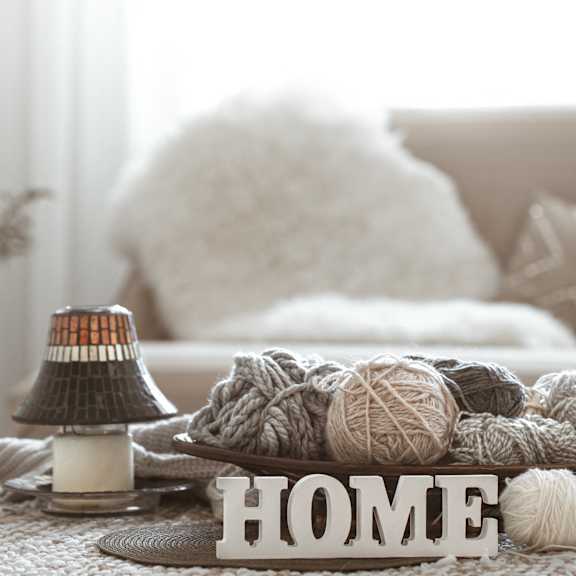a table with balls of yarn and a home sign on it