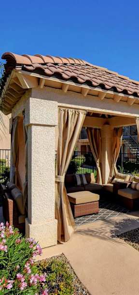 a gazebo with curtains in a garden