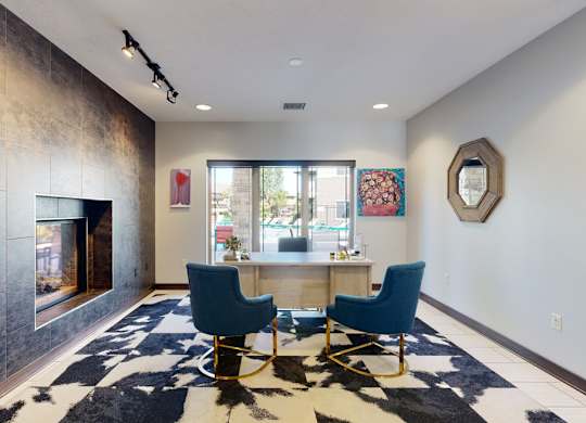 a office area with a table and chairs and a fireplace at the clubhouse