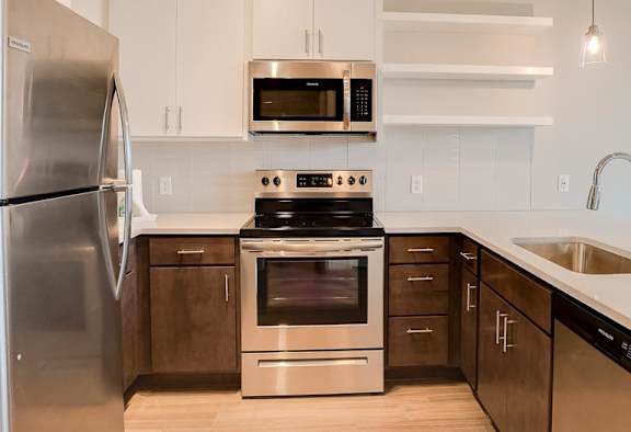 A modern kitchen with a stainless steel refrigerator and a stove top oven.