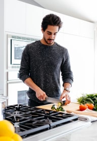 A man is chopping vegetables on a cutting board in a kitchen. at The Aviator, Renton, 98055