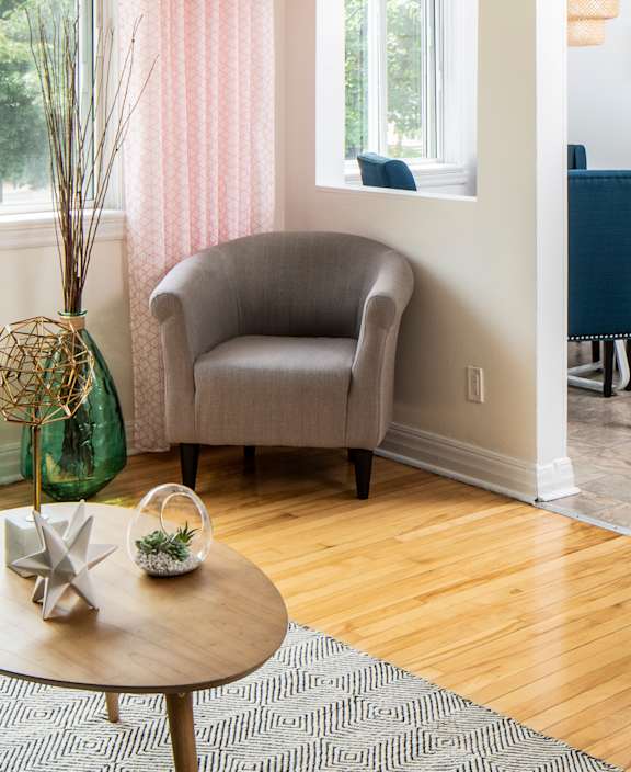 A living room with a white couch and a dining table.
