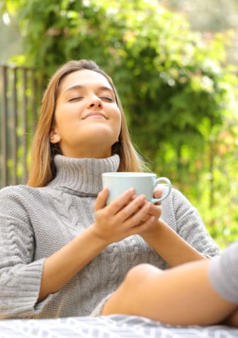 Woman Sitting on Patio with Coffee Mug