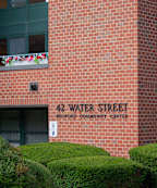 A brick building with a balcony and a sign that says 42 Water Street.