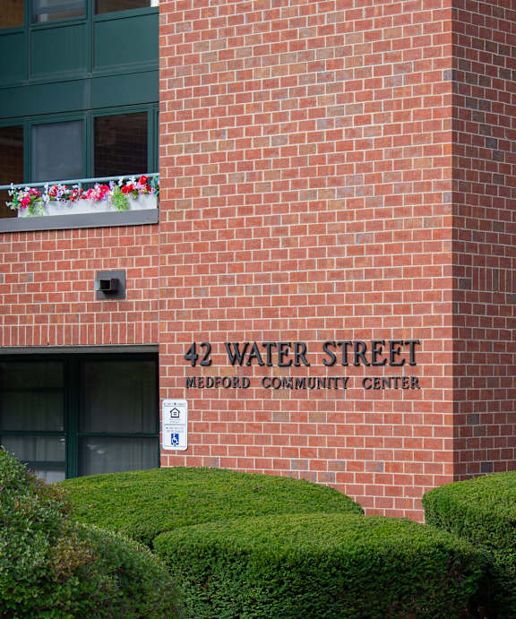 A brick building with a balcony and a sign that says 42 Water Street.