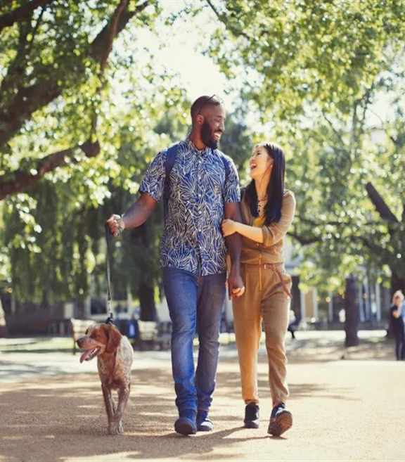 Couple walking their dog in park at The Bosk Apartment Homes, Woodbury, Minnesota