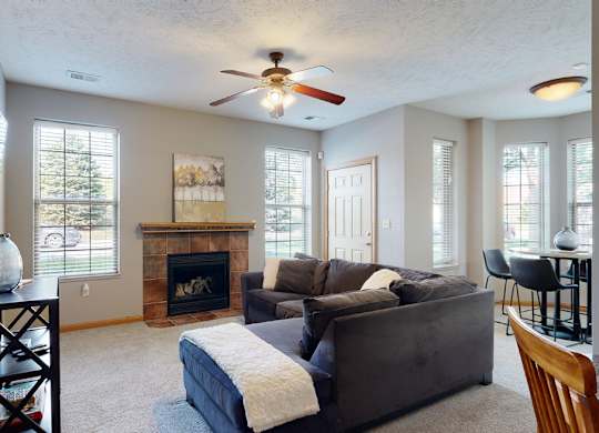 a living room with a sectional couch next to a fireplace