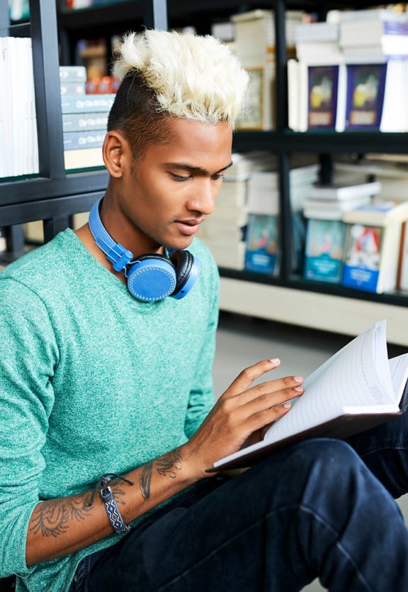 this is a photo of a young man reading at the local bookstore.