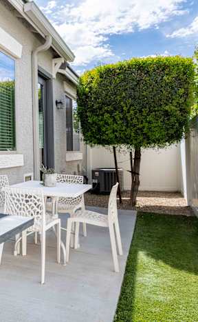 A house with a red door is surrounded by a green lawn at Vistoria At Country Place Apartments, Tolleson, Arizona