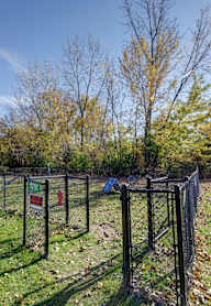 A chain link fence surrounds a green field.