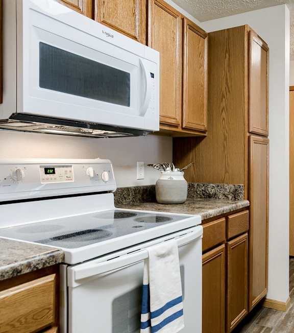 A kitchen with a white oven and microwave above it.